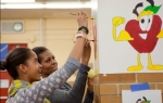 First Lady Michelle Obama and daughter Malia paint during a service project in the cafeteria of Stuart Hobson Middle School in Washington, D.C., Jan. 17, 2011. (Official White House Photo by Samantha Appleton)